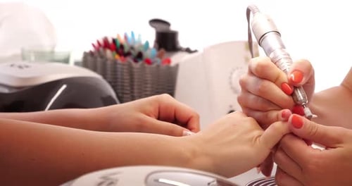 Close up of Beautician with Electric Nail Drill in Beauty Manicure Salon