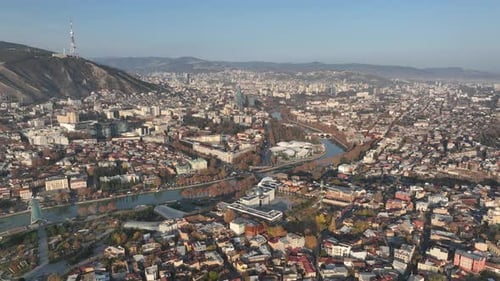 Aerial panoramic view of Tbilisi, Georgia, with the Kura River, city center, and Mount Mtatsminda