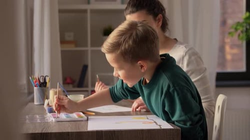 Blond Boy and Woman Painting Together Indoors