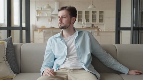 Man Relaxing on Couch Watching Television