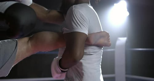 Frappe de jambe puissante sur le ring, le combattant donne un coup de pied lors d'une confrontation au ralenti tandis que l'adversaire défend