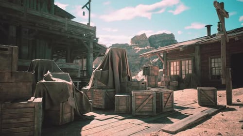 Deserted Western Town with Covered Crates and Wooden Buildings in Daylight
