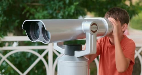 Child Observing Through Binoculars at Outdoor Viewing Point