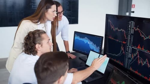 Team of stockbrokers works together in modern office at daytime