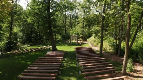 Aerial, empty outdoor forest woods ceremony event venue during the summer day