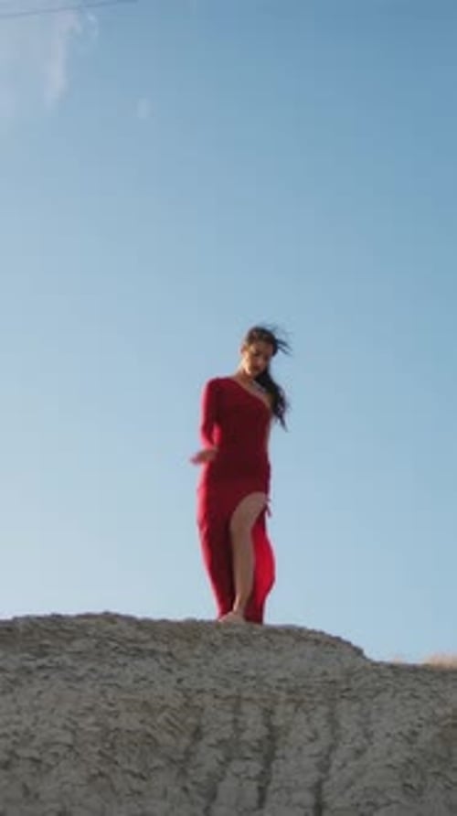Woman In Red Dresses Dancing On A Hill Near An Electrical Pylon