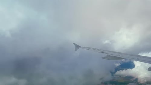 Airplane flight. Wing of an airplane flying through the clouds