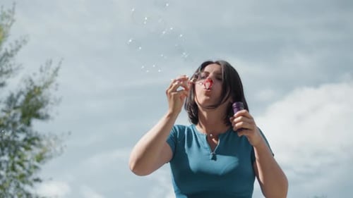 Child Joy Outdoors, femme en tenue décontractée, s'amuse avec des bulles de savon, femme à l'extérieur, décontractée