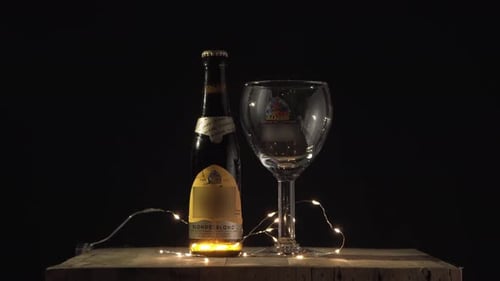 Beer Bottle with Glass on Wooden Table at Night