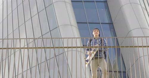 A boy practices skateboarding in the middle of the city, between buildings and skyscrapers. Concep