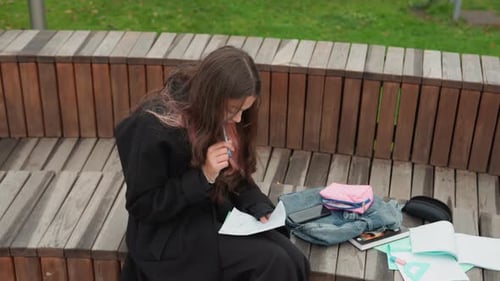 Student Absorbed in Exam Preparation Intense Revision Session in Cloudy Park Candid Moment of