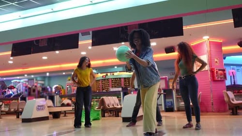 Junge Leute spielen Bowling in Zeitlupe