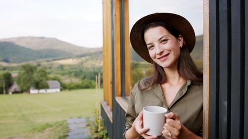 Young Woman with Coffee Outdoors, Weekend Away in Container House in Countryside