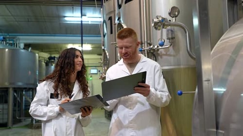 Ouvriers de brasserie inspectant l'équipement d'une usine de bière moderne