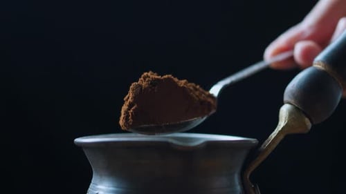 Pouring Ground Coffee Into Cezve with Teaspoon Close Up Side View
