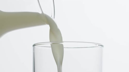 Milk Pouring in Glass Cup Closeup Glass with Yogurt Dairy Products Concept Drinking Fresh