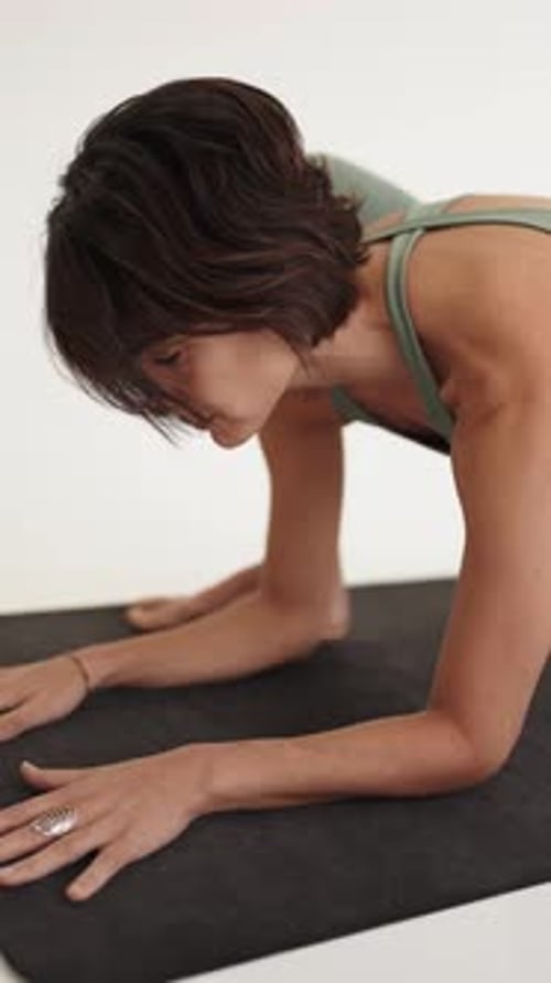Gelassene Yoga-Praktizierende führt drinnen eine Asana durch