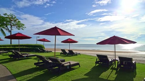 red umbrella and beach chair with sea beach background and blue sky and sunlight