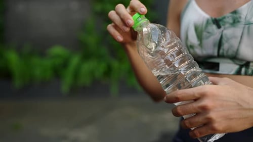 Woman Drinking Water After Exercise in Urban Park