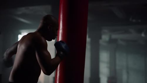 African american boxer training strength energy in dark gym preparing fight