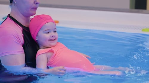 Menina começa a mergulhar suavemente sem flutuar na piscina azul transparente