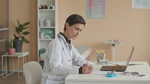 Portrait of Female Doctor Doing Paperwork in Office