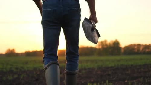 Bauer mit Gummistiefeln Schaufel Weizenfeld Sonnenuntergang Frühling Landwirtschaft Landwirtschaft Ernteernte