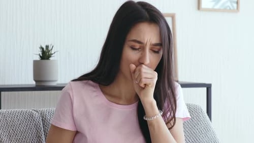 Jeune femme tousse à la maison isolée en raison d'une maladie