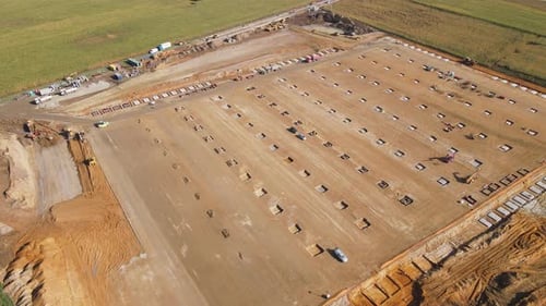 Aerial view of construction site with foundation works and machinery