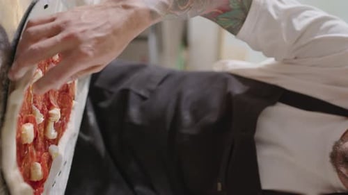 Chef Preparing a Pizza in Restaurant Kitchen
