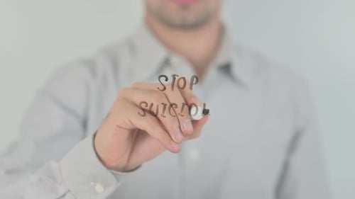 Man Writes "Stop Suicide" on Transparent Surface