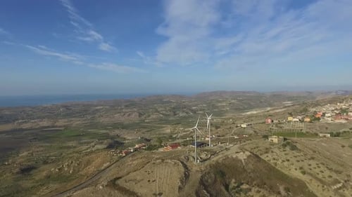 Aerial view of wind turbines on a hill overlooking rural landscape near Agrigento, Sicily, Italy,