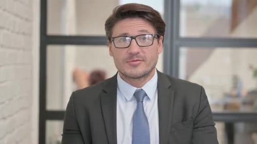 Blogging Businessman Doing Video Chat in Office