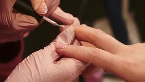Manicurist Applying Nail Polish to Woman's Nails