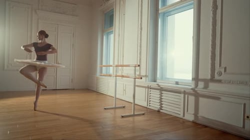 Female Ballerina Practicing Ballet in Bright Studio