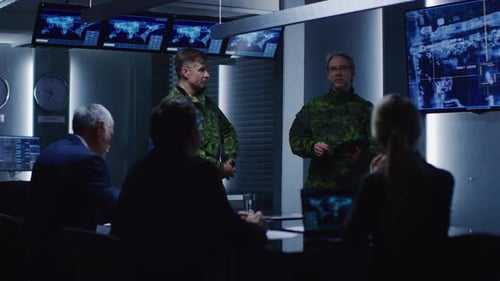 Military personnel meet in high tech command center