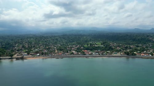 Flying sideways over the sea with the coast and Sao Tome city in the background. Africa