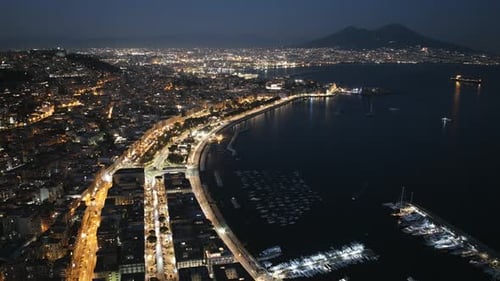 Static aerial hyperlapse of Naples, Italy at night with Mount Vesuvius in the background.
