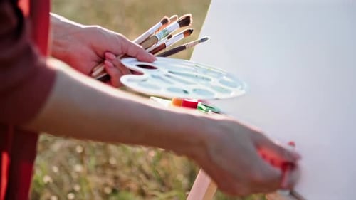 Talented Female Artist Picking Up Acrylic Paints with Brushes to Paint a Picture Closeup