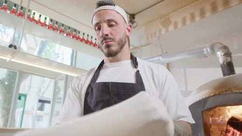 Man Shaping Pizza Dough in Restaurant Kitchen