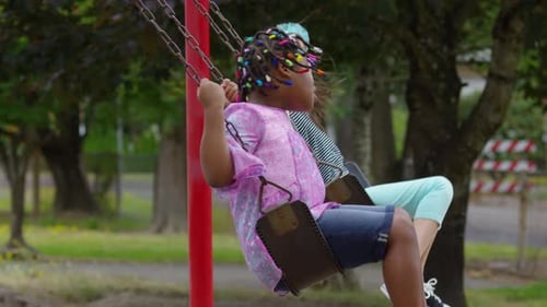 Children Playing on Swings at the Park