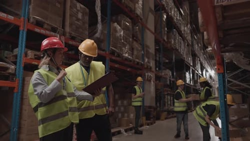 Warehouse workers discussing inventory