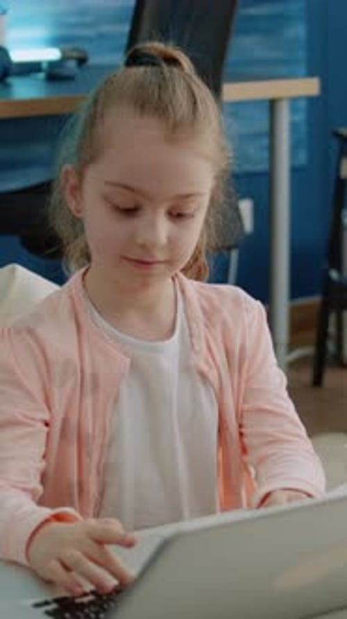 Vertical Video Young Child Using Keyboard on Laptop for Homework and Online Courses