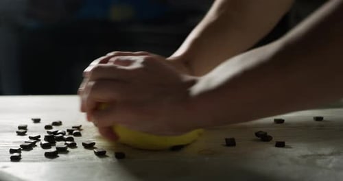 Zeitlupe eines Kochs, der einige Schokoladenstückchen in den Teig gibt, um ein Dessert zuzubereiten. Konzepte von