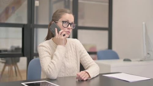 Young Woman Talking on phone in Office