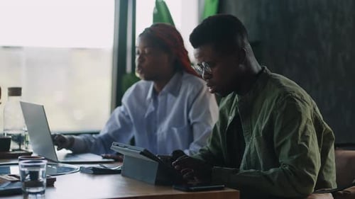 At a Meeting in a Cafe Two Black Employees Complementing Each Other Discuss Important Aspects of a