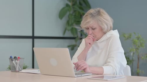 Senior Woman Coughing While Working at Computer