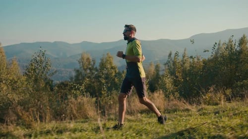 Seitliche Ansicht: Fitness, kaukasischer männlicher Mann, laufender aktiver Ausdauersport, Trailrunning, Wandern, Laufen
