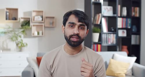 Young Adult Man Speaking Directly to Camera at Home