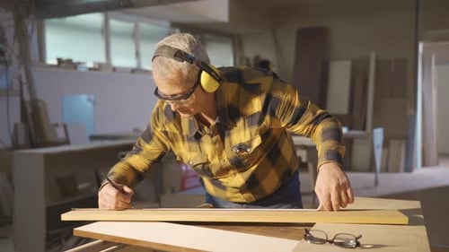 Measure wood. The carpenter measures the board with the meter.